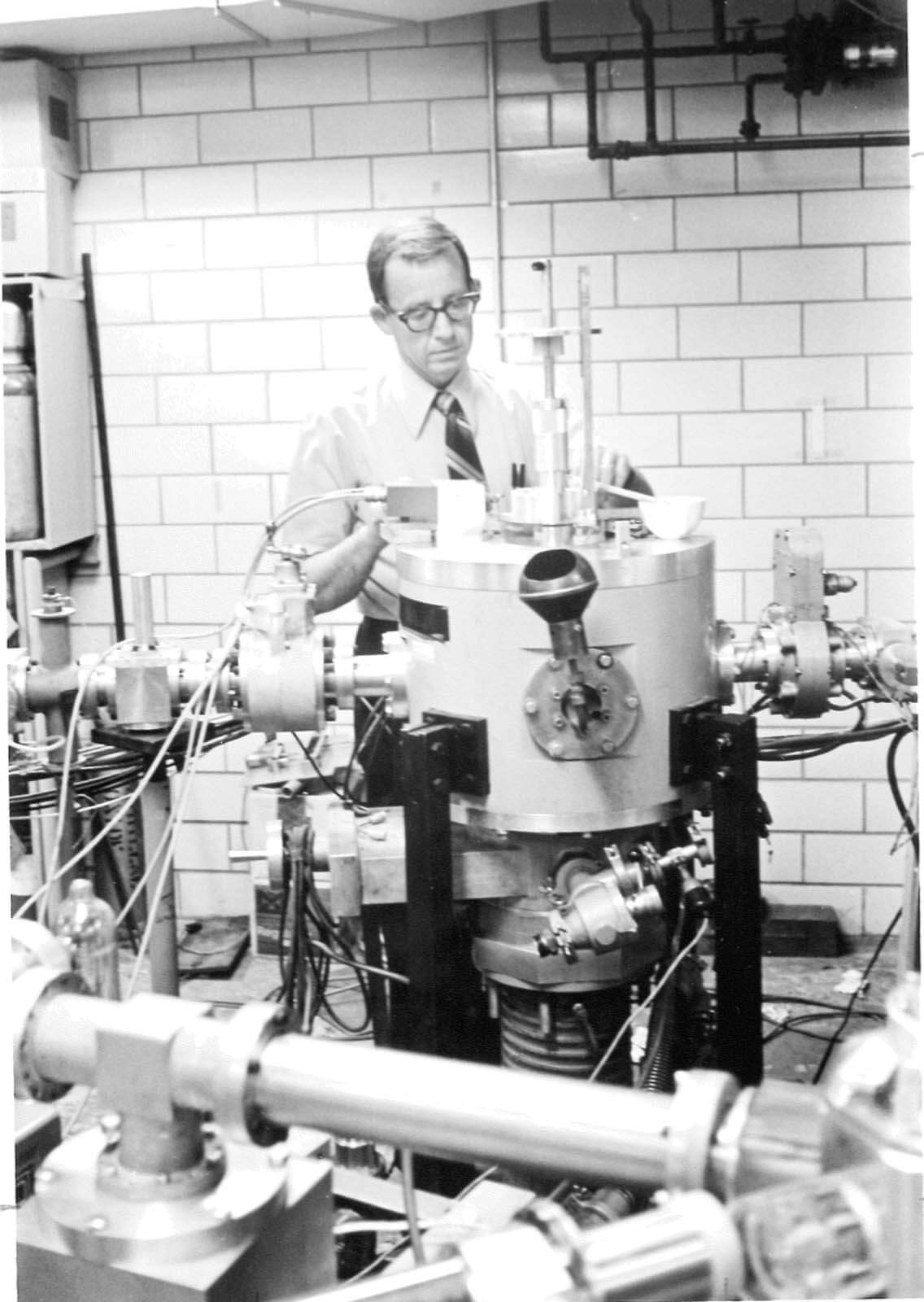 A vintage photo of a researcher works with a piece of equipment