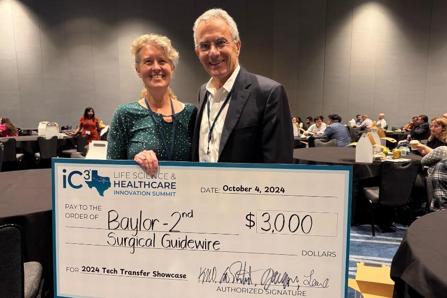 Linda Olafsen and Gregory Echt and a large check.